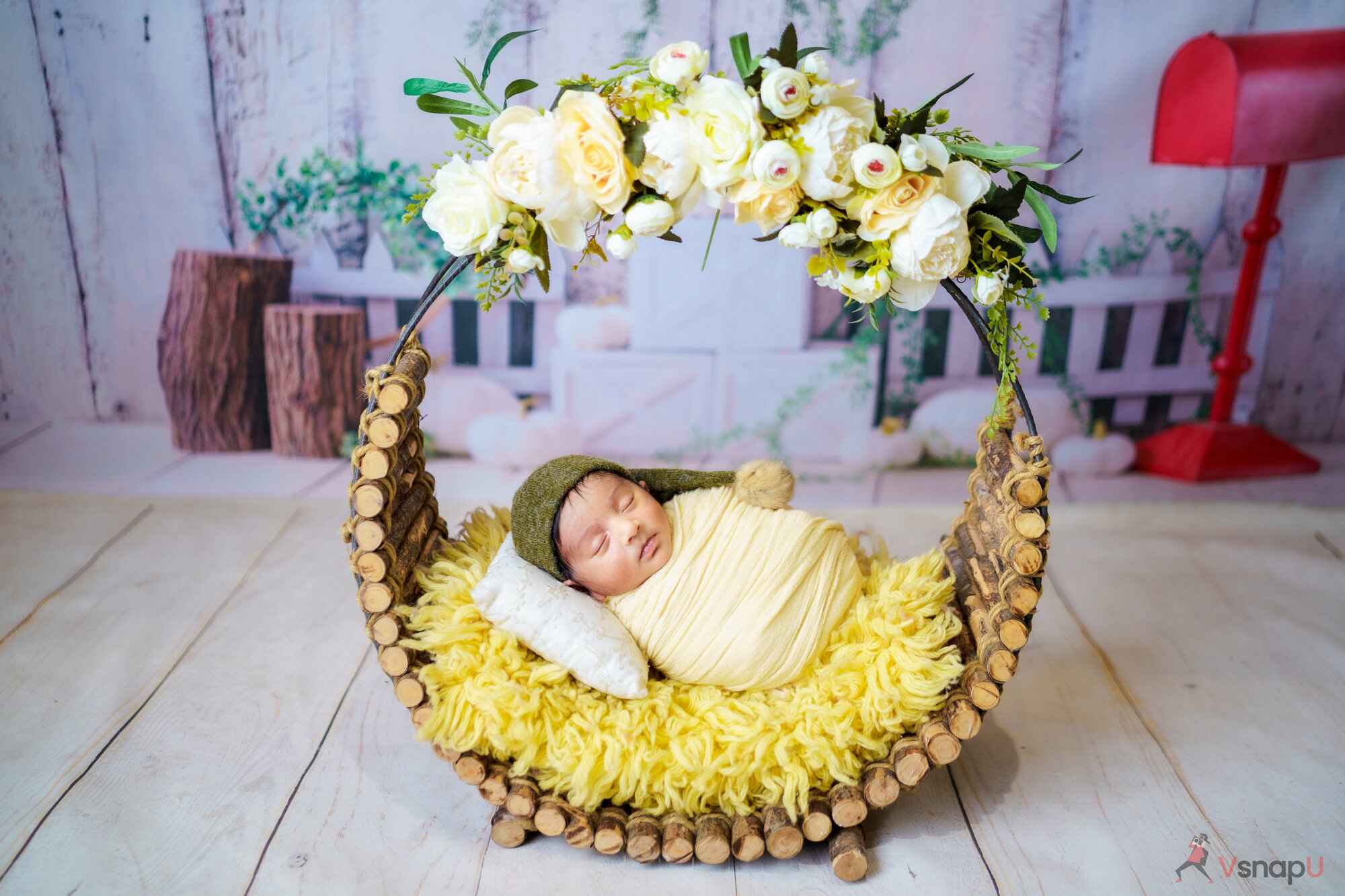 A peaceful baby nestled in a floral basket, sleeping soundly during a baby photoshoot.